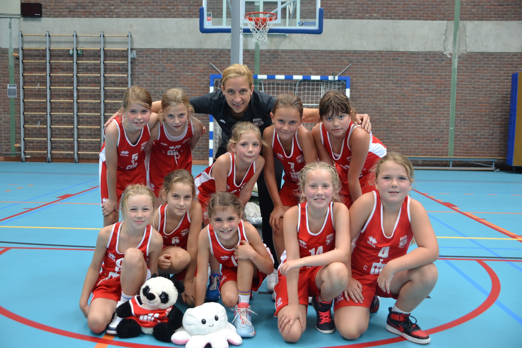 Groep basketmeisjes poseert voor foto