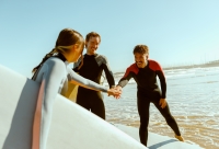 drie surfers op het strand