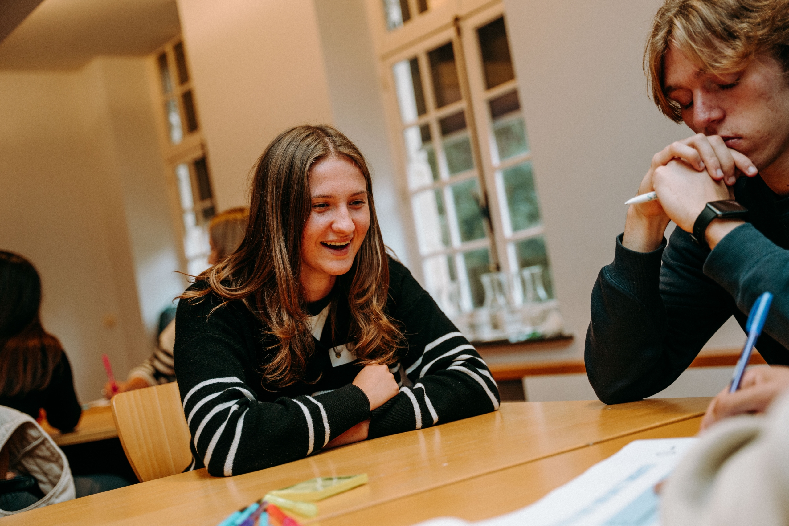 Studente in groep aan tafel tijdens brainstorm