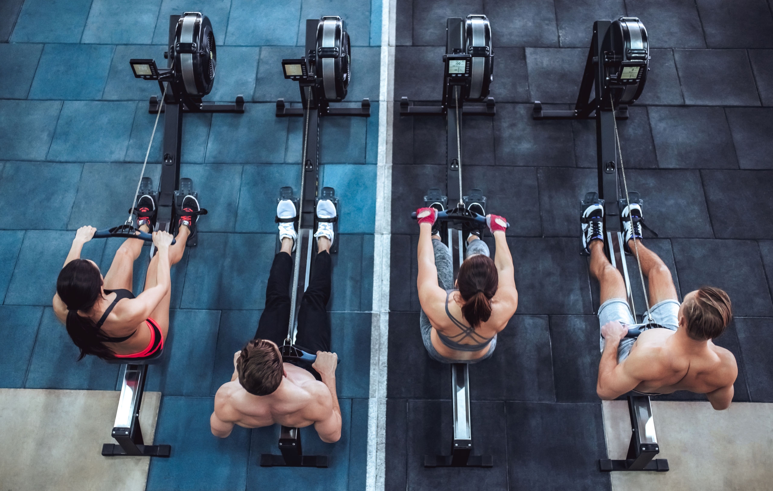 vier sporters trainen op ergometer