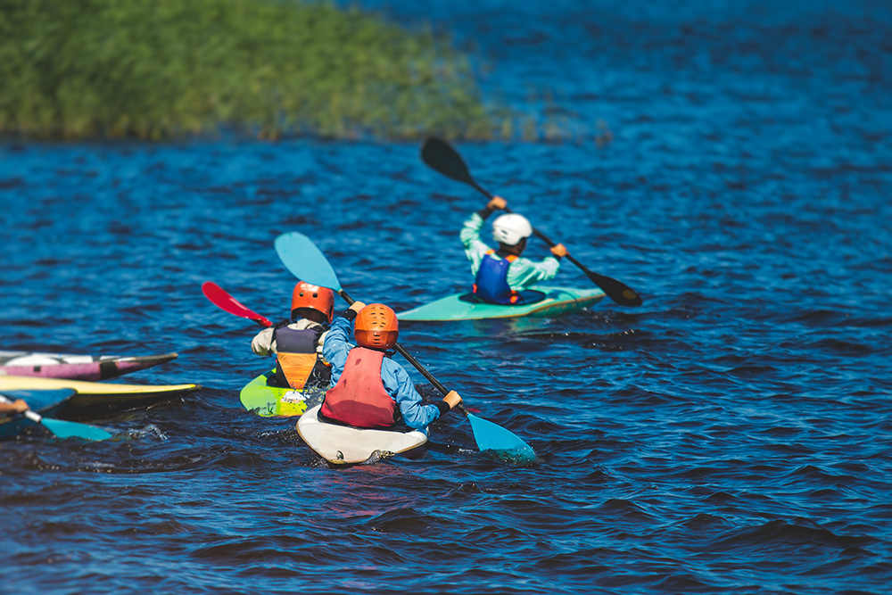 3 kinderen aan het kajakken op het water