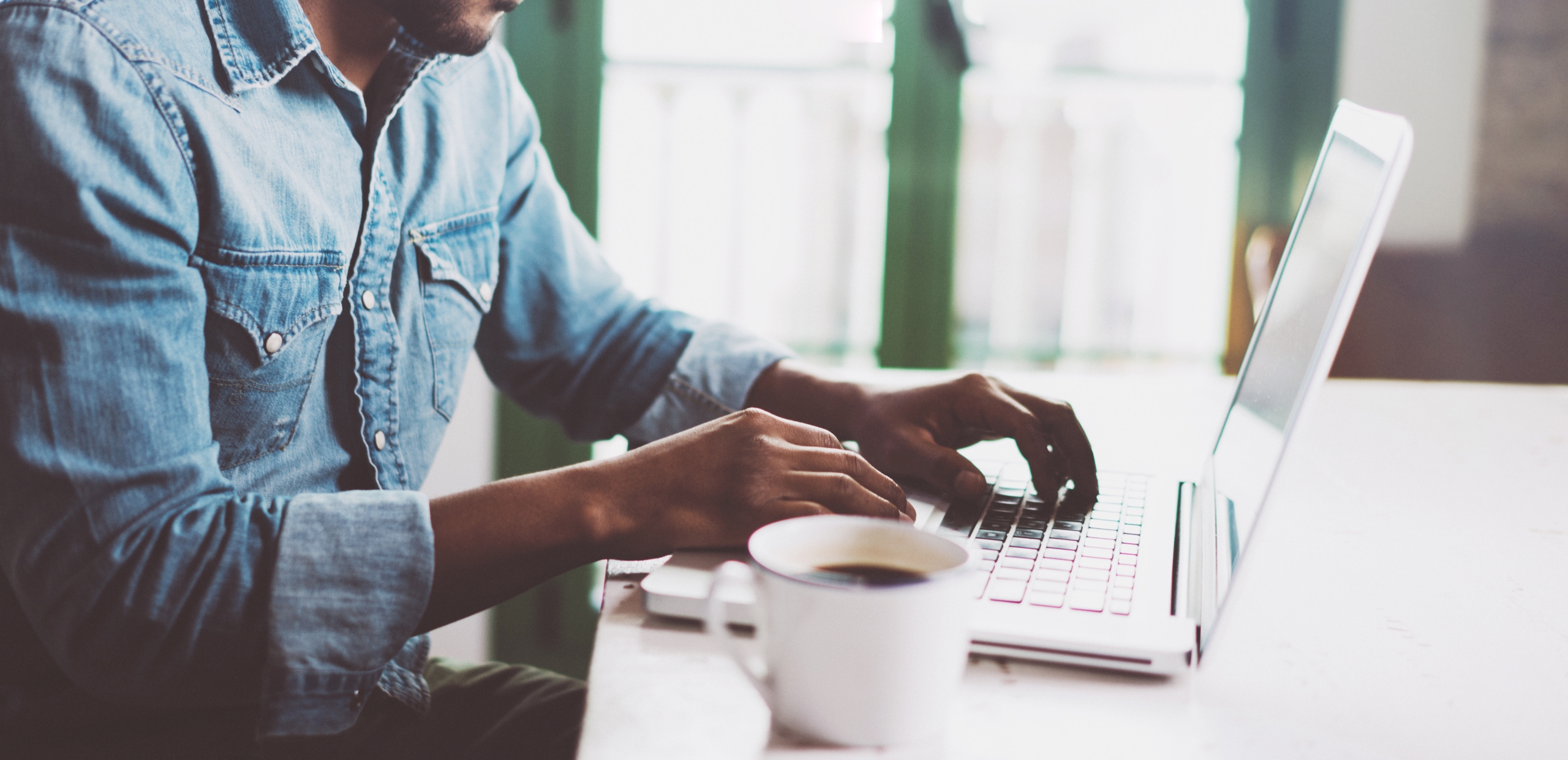 man werkt op flexdesk met tas koffie