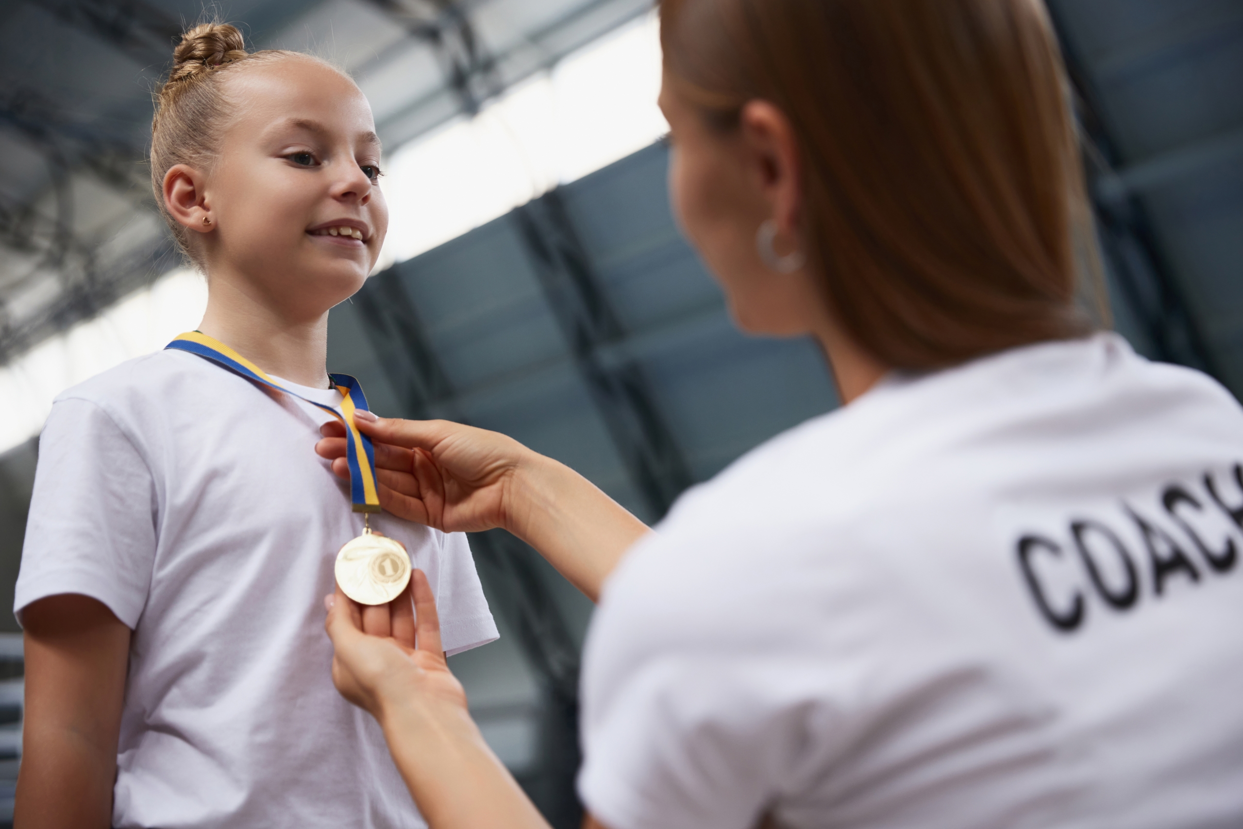 meisje krijgt medaille van coach