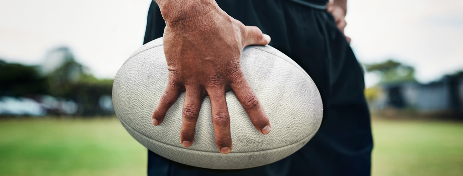 man staat met rugbybal op het veld