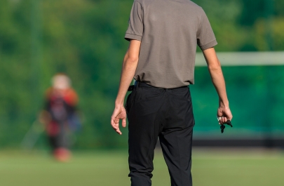 scheidsrechter staat naast het veld