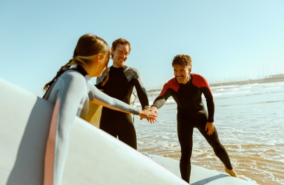 drie surfers op het strand