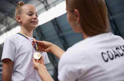 meisje krijgt medaille van coach