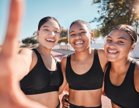 drie sportieve meisjes maken een selfie