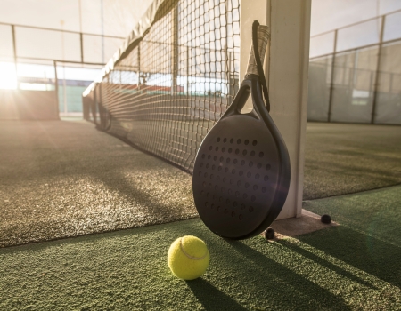 padelveld met racket op de voorgrond