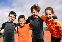 groepsfoto met 4 kinderen op een atletiekpiste