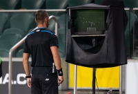 Scheids bekijkt uitslag van de VAR tijdens voetbalmatch
