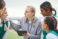 coach in gesprek met een meisjesteam