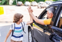 ouder neemt afscheid van zoon vanuit de auto