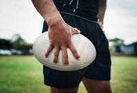man staat met rugbybal op het veld